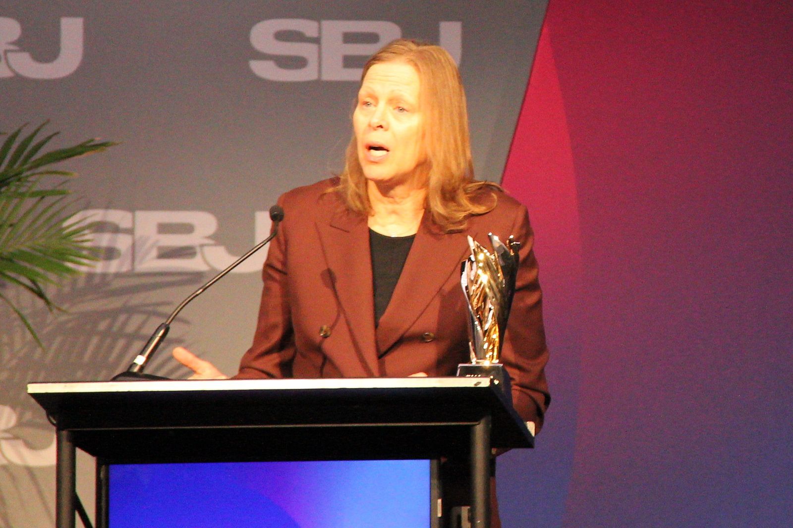 Val Ackerman speaks at a podium with the award beside her