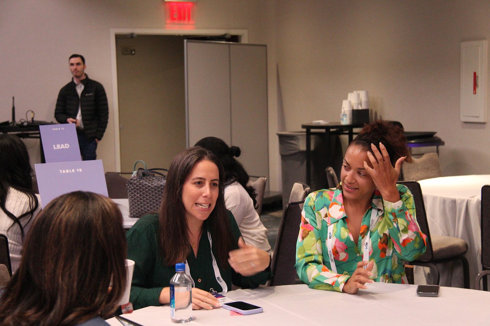 Two attendees in conversation at a Lead table