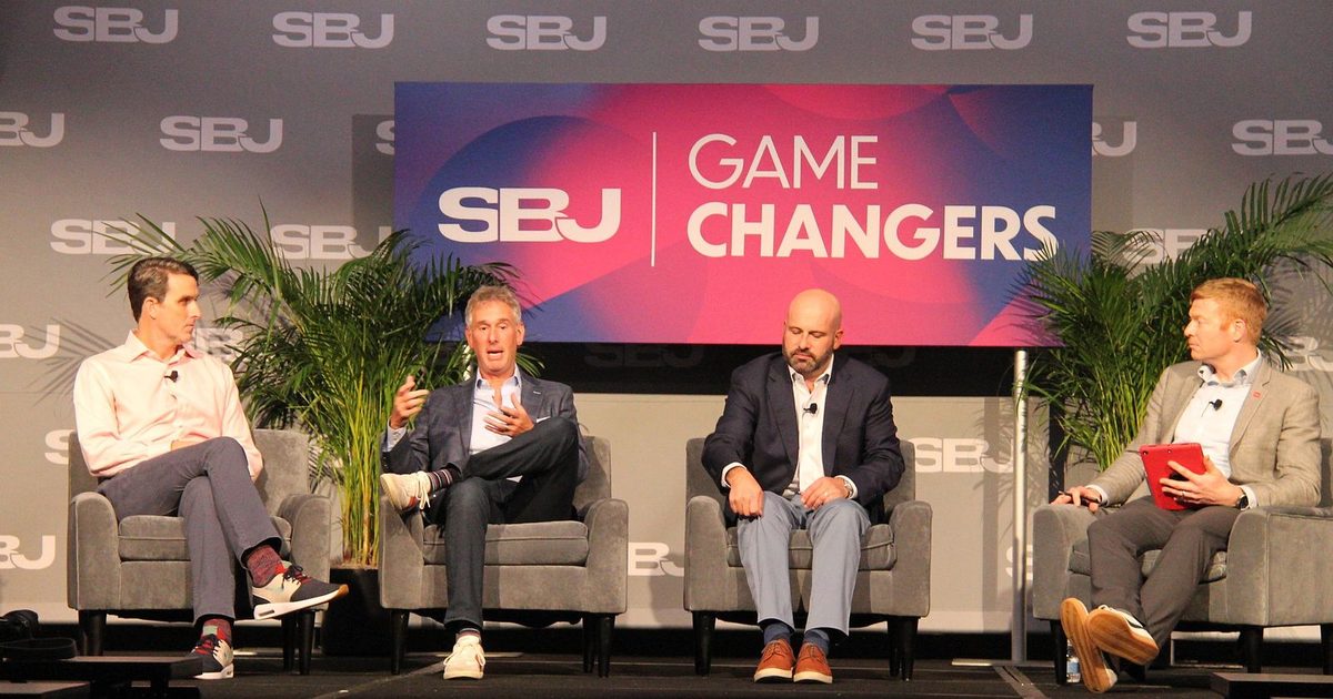 Four men seated on stage during the prediction markets panel as the second from left speaks