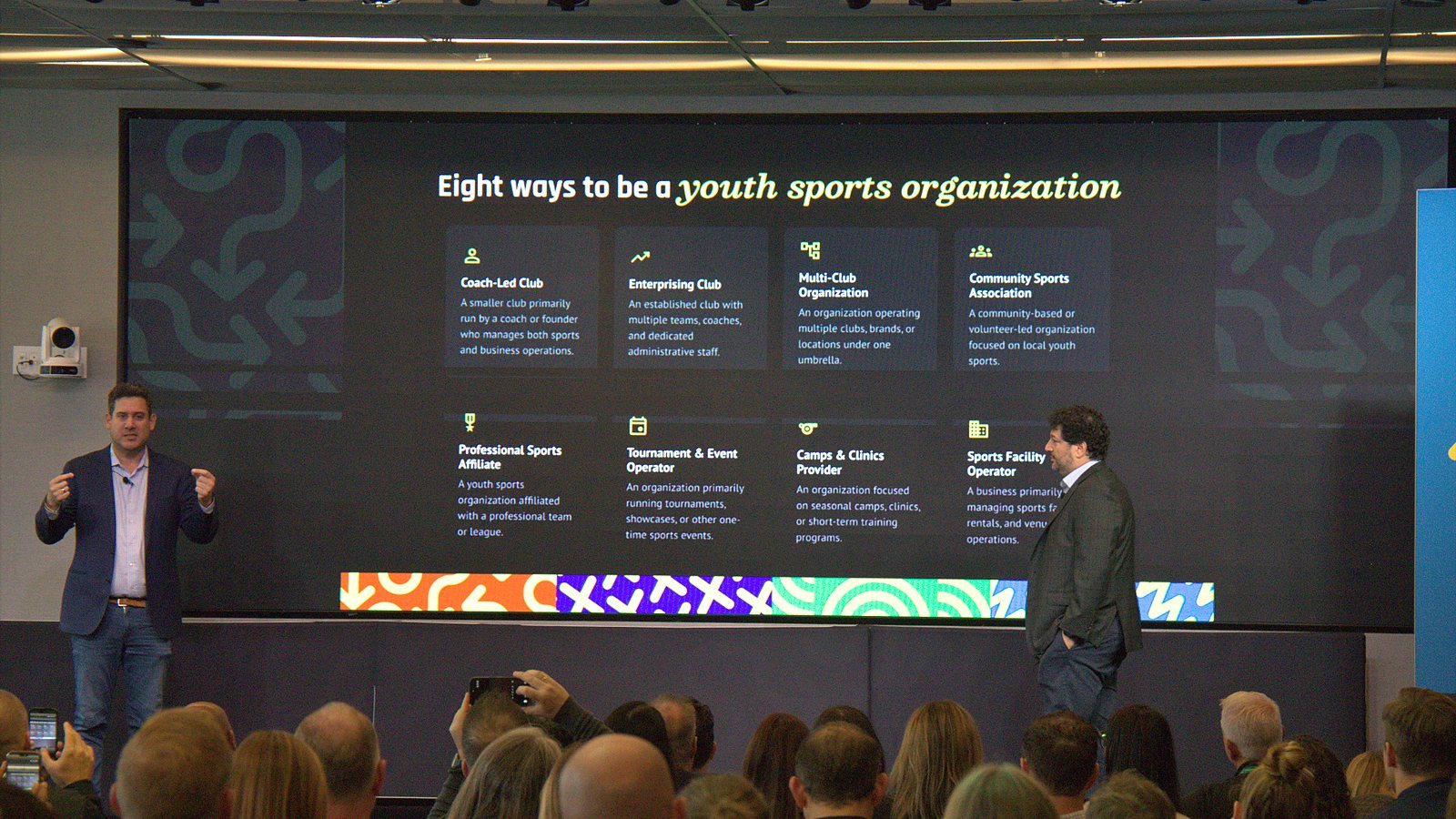 Brian Litvack and Jeremy Goldberg on stage in front of a slide titled Eight ways to be a youth sports organization
