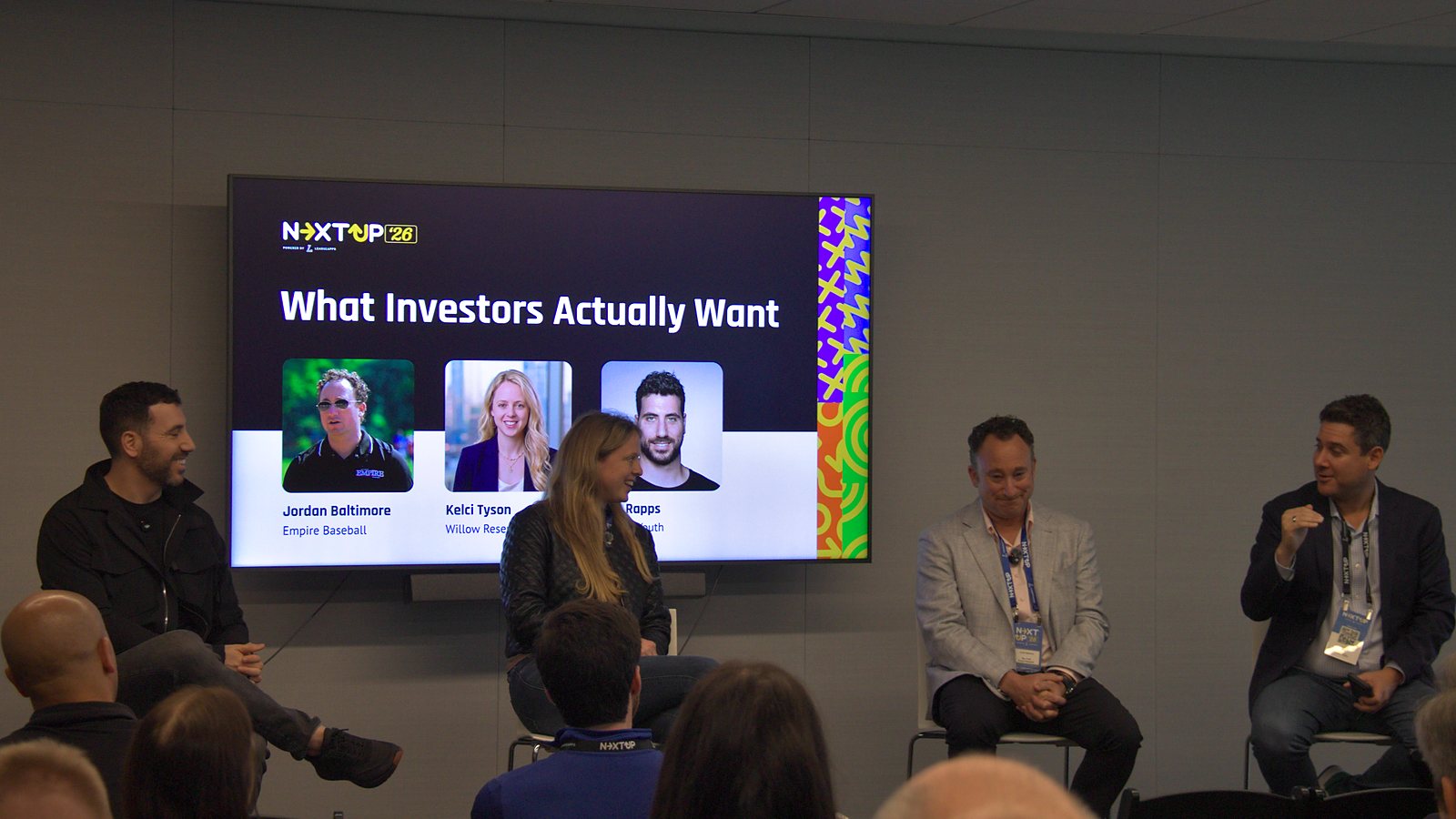 Eric Rapps, Kelci Tyson and Jordan Baltimore seated in front of a screen reading What Investors Actually Want, with the moderator speaking at right